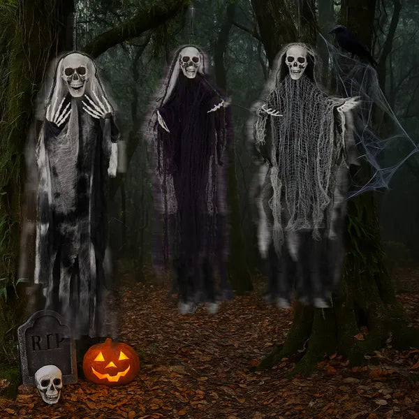 Set of three grim reaper decorations hanging from a tree branch
