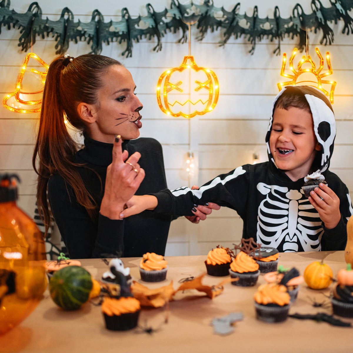 Set of three Halloween window lights displayed together on a window